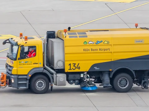 Yellow airport runway sweeper truck